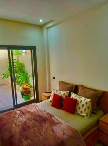 een slaapkamer met een groot bed met rode kussens bij luxury house with garden view close to beach in Casablanca