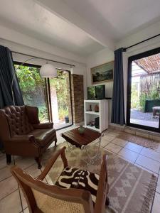 a living room with a couch and a table at Santika Garden Cottage Stellenbosch in Stellenbosch