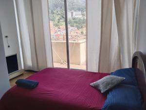 Ce lit se trouve dans un dortoir doté d'une grande fenêtre. dans l'établissement Habitaciones Centro Histórico, ed, continental, à Bogotá