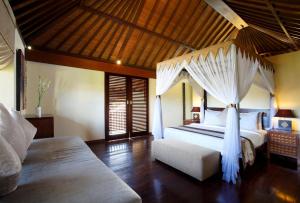 a bedroom with a bed with a canopy at Lalasa Villas Canggu in Canggu
