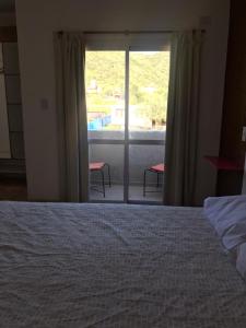 1 dormitorio con 1 cama y puerta corredera de cristal en Cabaña Privada en Comuna San Roque en Bialet Massé