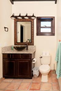 a bathroom with a sink and a toilet and a mirror at X'tan Ha- The Waterfront in San Pedro