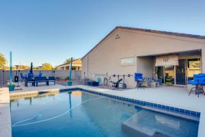 een zwembad voor een gebouw met blauwe stoelen bij Phoenix Area Vacation Home with Private Pool! in Buckeye