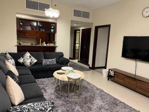 a living room with a black couch and a table at هافانا المارينا Apartment in King Abdullah Economic City