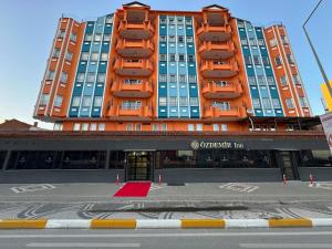 a tall orange building with a red rug in front of it at Özdemir Inn Otel in Balıkesir +21 photos