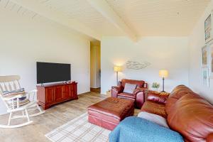 ein Wohnzimmer mit Couch und Fernseher in der Unterkunft Gathering Together Cabin in Gig Harbor