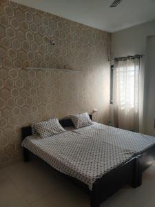 a bedroom with a bed in a room with a wall at Away From Home, Furnished Apartment in Bhopal