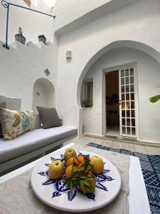 a plate of fruit on a table in a living room at Dar Ali Médina Hammamet chambres d'hôtes in Hammamet