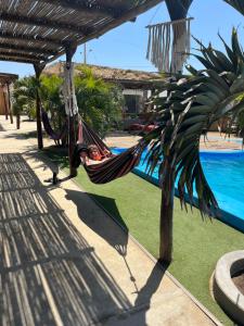 a person sleeping in a hammock next to a pool at Aloha Lobitos in Lobitos