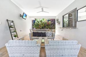 a living room with a couch and chairs at Flagship Villa in Trinity Beach