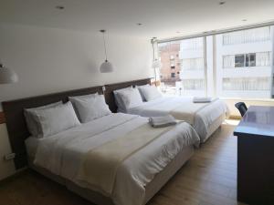 twee bedden naast elkaar in een kamer bij Balmoral 103 in Bogota