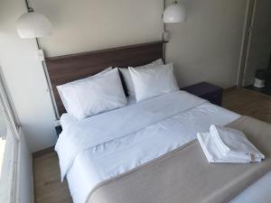 een groot wit bed met witte lakens en kussens bij Balmoral 103 in Bogota