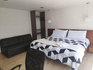 - une chambre avec un lit et un canapé noir dans l'établissement Balmoral 103, à Bogotá