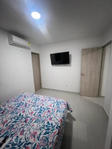 1 dormitorio con 1 cama y TV de pantalla plana en EDIFICIO BUENOS AIRES 1 Habitación en Sincelejo