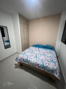 a bedroom with a bed with a colorful comforter at EDIFICIO BUENOS AIRES 1 Habitación in Sincelejo