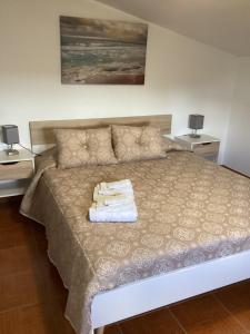 a bedroom with a bed with two towels on it at VISTA MAR in Lourinhã