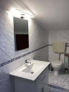 a white bathroom with a sink and a toilet at VISTA MAR in Lourinhã +28 photos