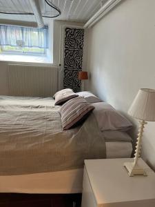 a bedroom with a bed and a lamp and a window at Independent apartment in Borås in Borås