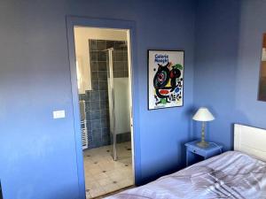 a blue bedroom with a bed and a picture on the wall at Agréable chambre d'hôtes avec vue sur les collines in La Colle-sur-Loup