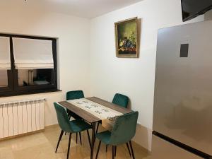 a dining room with a wooden table and green chairs at Mountain View Apartment in Piatra Neamţ
