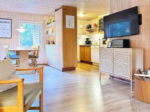 Mølbyにある6 person holiday home in R mの広いリビングルーム(テレビ付)、キッチンが備わります。