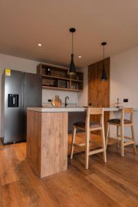 a kitchen with a stainless steel refrigerator and wooden cabinets at Kiin Living - Adults Only in Medellín