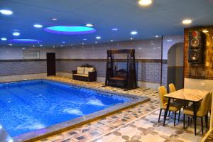 una piscina en una habitación de hotel con una mesa y una mesa en منتجع شاطئ العرب الرايس, en Rayyis