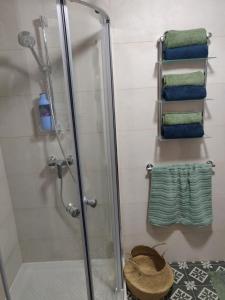 a shower with a glass door and towels in a bathroom at Central Malta Apartment in Birkirkara