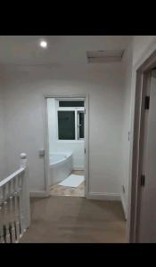 ein weißes Bad mit einer Badewanne und einem Fenster in der Unterkunft Mirandas Place in Gillingham