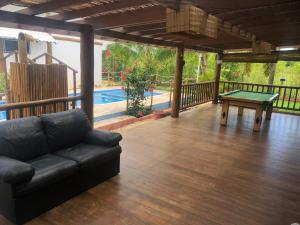 een woonkamer met een bank en een tafeltennistafel bij Ao som do mar Bahia in Marau +5 foto's