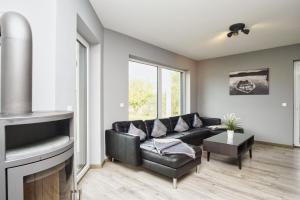 a living room with a black couch and a fireplace at Haus in idyllischer Lage mit Sauna, Terrasse und Garten - Villa Mondlicht in Vaschvitz