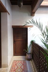 a wooden door of a house with a rug in front at Dar Rafti in Fez
