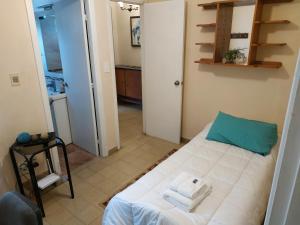 a small room with a bed with towels on it at Hermoso Apto de 3 Dormitorios 86m2 en Tres Cruces in Montevideo