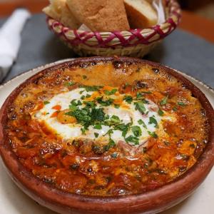 a bowl of food sitting on a plate with chips at Dar Rafti in Fez