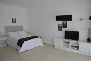 a bedroom with a bed and a flat screen tv at Harbour Studio in the WTC BA in Buenos Aires