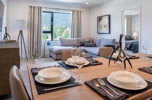 a living room with a table with plates and wine glasses at The Stoke Stopover - Revelstoke Condo with Hot Tub in Revelstoke