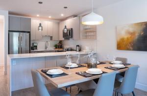 a kitchen and dining room with a wooden table and chairs at The Stoke Stopover - Revelstoke Condo with Hot Tub in Revelstoke