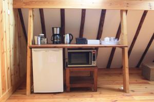 a table with a microwave and a refrigerator in a room at Bed & Breakfast De Stolp in Zuidoostbeemster