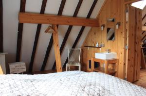 1 dormitorio con cama y lavamanos en Bed & Breakfast De Stolp, en Zuidoostbeemster
