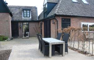 a table and chairs in front of a house at Bed & Breakfast De Stolp in Zuidoostbeemster