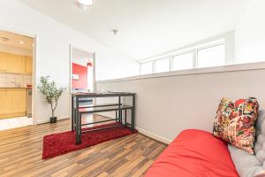 a living room with a red couch and a table at Dockside Penthouse Albert in Liverpool +10 photos