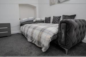 een slaapkamer met een bed met een deken en een dressoir bij The house in Barking