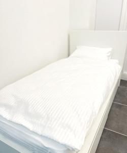 uma cama branca com lençóis brancos em cima em Wohnung alleinige Nutzung 30qm 4 Schlafplätze Wiesbaden em Walluf