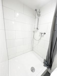 y baño con ducha de azulejos blancos. en Wohnung alleinige Nutzung 30qm 4 Schlafplätze Wiesbaden, en Walluf