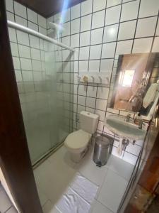 a bathroom with a toilet and a sink and a mirror at Casa Gaúcho in Morro de São Paulo