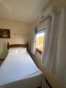 um pequeno quarto com uma cama e uma janela em Casa Gaúcho em Morro de São Paulo
