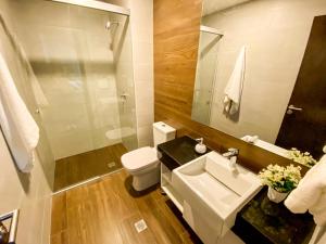 W łazience znajduje się umywalka, toaleta i lustro. w obiekcie Departamento Elegante y Relax by Torre Vento w mieście Santa Cruz de la Sierra