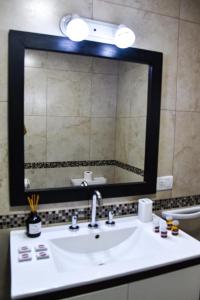 a bathroom with a sink and a large mirror at Mendoza Aparts - Con cochera in Villa María +14 photos