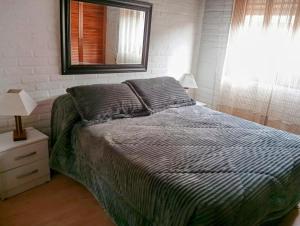 a bedroom with a bed with a mirror and a window at El sabia in Piriápolis