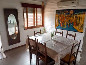 a dining room with a table and chairs and a painting at El sabia in Piriápolis